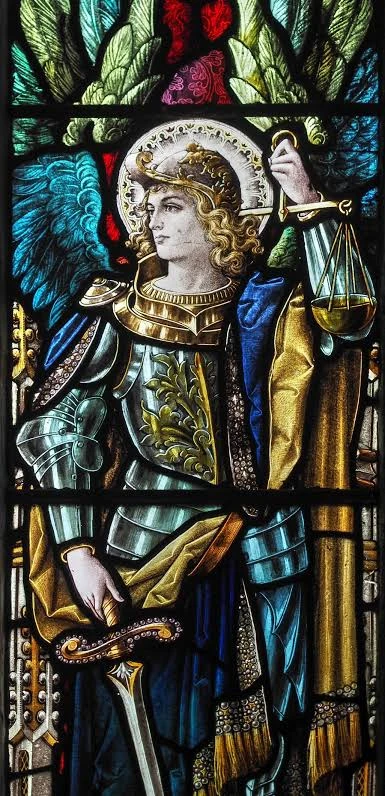 Stained glass window of St Michael the Archangel holding the scales